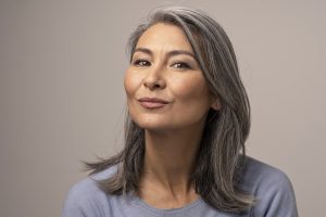 Charming Asian Woman With Grey Hair With Delicate Smile. 