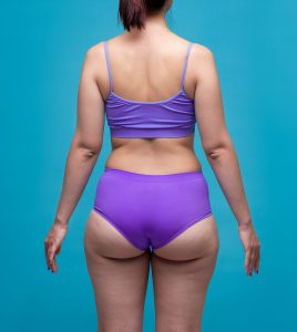 Backside of a woman wearing a purple bra and underwear