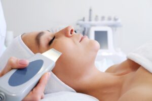 Close-up of young woman's face during ultrasonic peel skin procedure at spa salon